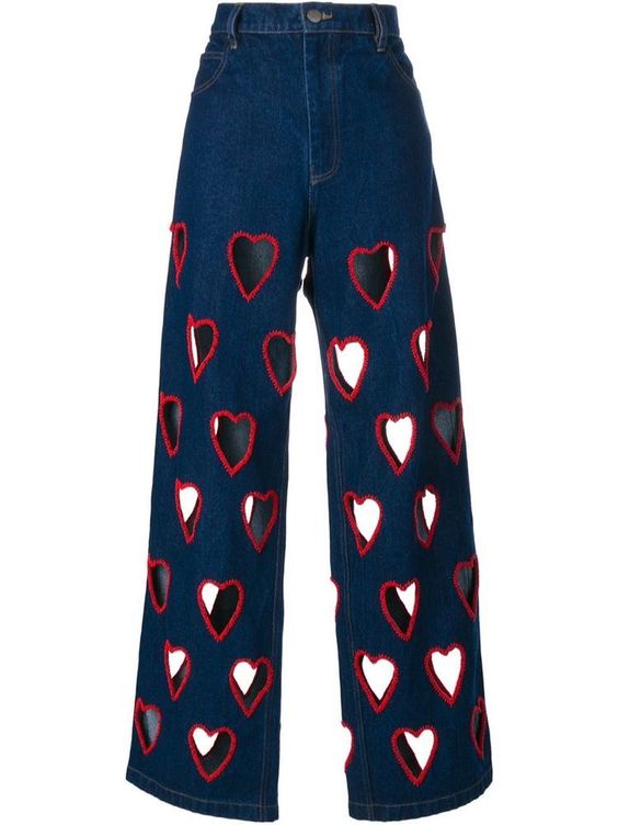 Flared jeans with heart-shaped holes along the leg, highlighted with red thread